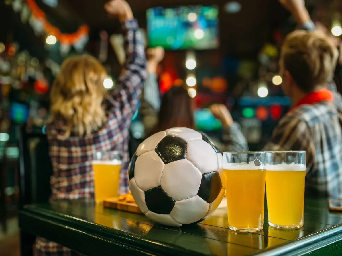Prieteni care urmăresc un meci de fotbal la pub